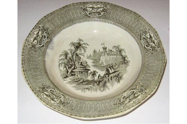 Late 19th century glazed ceramic plate manufactured by the Clyde Pottery Company, Greenock. Decorated with the 'Washington' pattern showing scene across a river gorge with castellated building with flag. Well-dressed figures descend a monumental stair. In the foreground is a summerhouse at the lower left. The border has American eagles in reserves. - 1982.125 - © McLean Museum and Art Gallery, Greenock.