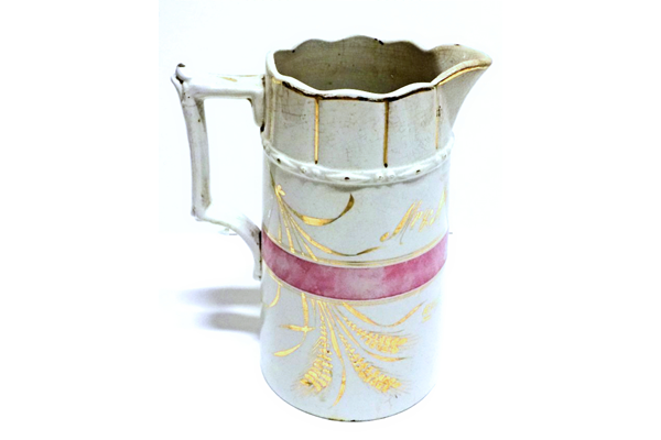 Marriage milk jug manufactured by the Clyde Pottery Company, Greenock. Decorated with pink band and gold wheat motif and inscribed 'Mr & Mrs Walter Campbell 2nd July 1890'. - 1997.117 - © McLean Museum and Art Gallery, Greenock.