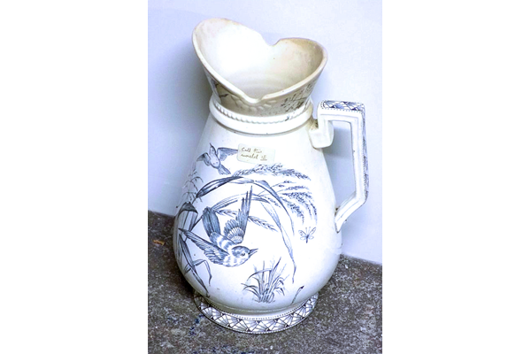 Ewer manufactured by the Clyde Pottery Company Limited, Greenock 1900-1905. Decorated with the 'Waldeck' pattern showing a geometric border with little birds flying through long grass stems and butterflies. - 1987.670 - © McLean Museum and Art Gallery, Greenock.