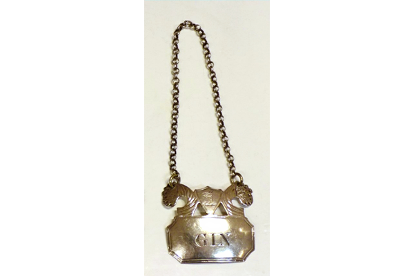 Early nineteenth century Greenock provincial silver gin label made by John Heron (fl 1815-1830). Hallmarked 'JH' (maker's initials John Heron), Edinburgh mark and duty mark, also engraved 'Gin'. - 2001.4.1 - ©McLean Museum and Art Gallery, Greenock.