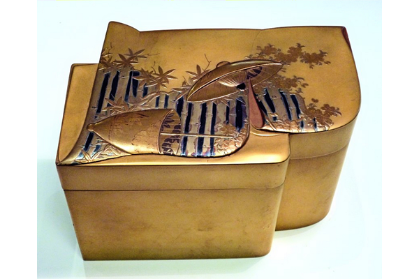 Japanese tea ceremony set box in lacquered wood. The box is in the form of a folded kimono decorated with a fence with a parasol. The interior is in nashiji lacquer. - 1981.194 - © McLean Museum and Art Gallery, Greenock