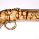 A mid 19th century glazed ceramic decorative pistol manufactured by the Clyde Pottery, Greenock with a glazed surface in mid and light brown colour.  
Inscription stamped on the barrel: 'John Philips Greenock 1867'. - 1977.129 - © McLean Museum and Art Gallery, Greenock.