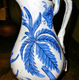 Late 19th century glazed ceramic jug manufactured by the Clyde Pottery Company, Greenock. The jug has a hand painted design on a white background with a mid blue design of plant foliage and forget-me-nots. - 1981.1594 - © McLean Museum and Art Gallery, Greenock.