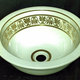 Late 19th century glazed ceramic wash basin manufactured by the Clyde Pottery, Greenock. 
Decorated in white with plug hole in centre surrounded by gold line; gilded decoration on inside; gilded lambrequin design bordered with gilt line top and bottom. - L1977.117 - © McLean Museum and Art Gallery, Greenock.
