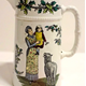 Christmas sauce jug manufactured by the Clyde Pottery Company, Greenock. The jug has a white background decorated with Christmas scenes. Inscribed 'A Joyous Xmas and a Happy New Year' with a mark C.P.Co. - 1980.320 - © McLean Museum and Art Gallery, Greenock.