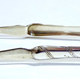 Greenock provincial silver sugar tongs. George III fiddle pattern with shell bowls and oblique fluted pattern on sides and with and engraved monogram 'A' on convex part. Two assay marks: an anchor for Greenock. Makers' mark 'AR' set inside rectangle on each limb above bowl on the inside. Dated around 1780. - 1980.33 - ©McLean Museum and Art Gallery, Greenock.