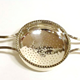 Greenock provincial silver juice strainer. George III period, made around 1815. Made by John Heron (fl 1815-1830) of Greenock. The design has a central perforated straining bowl with decorated outer edge. Two handles styled in elongated 'V' shape. - 1980.74